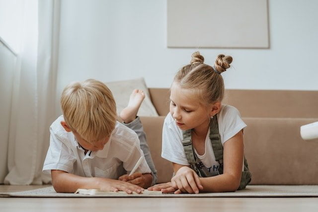 Un niño y una niña estudiando juntos en su casa después de su primer día de clase